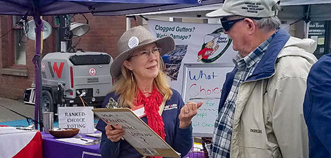 Advocate speaking to an interested person at a tabling event.